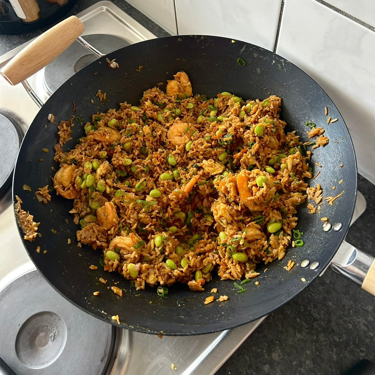 Bowl of garlic prawn and egg fried rice with green onions and tender prawns.