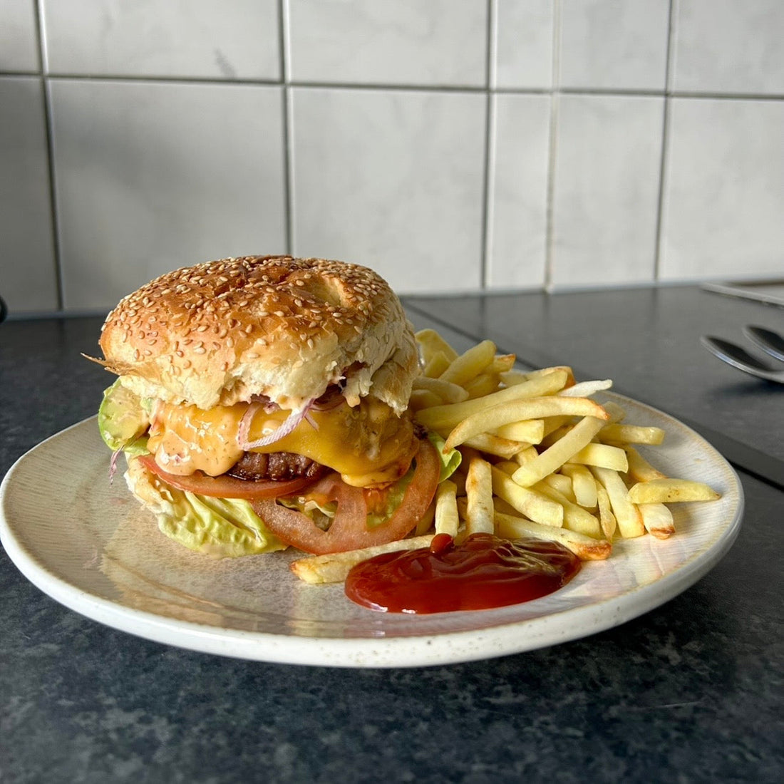 Beyond Meat burger with melted cheese served with crispy oven chips.