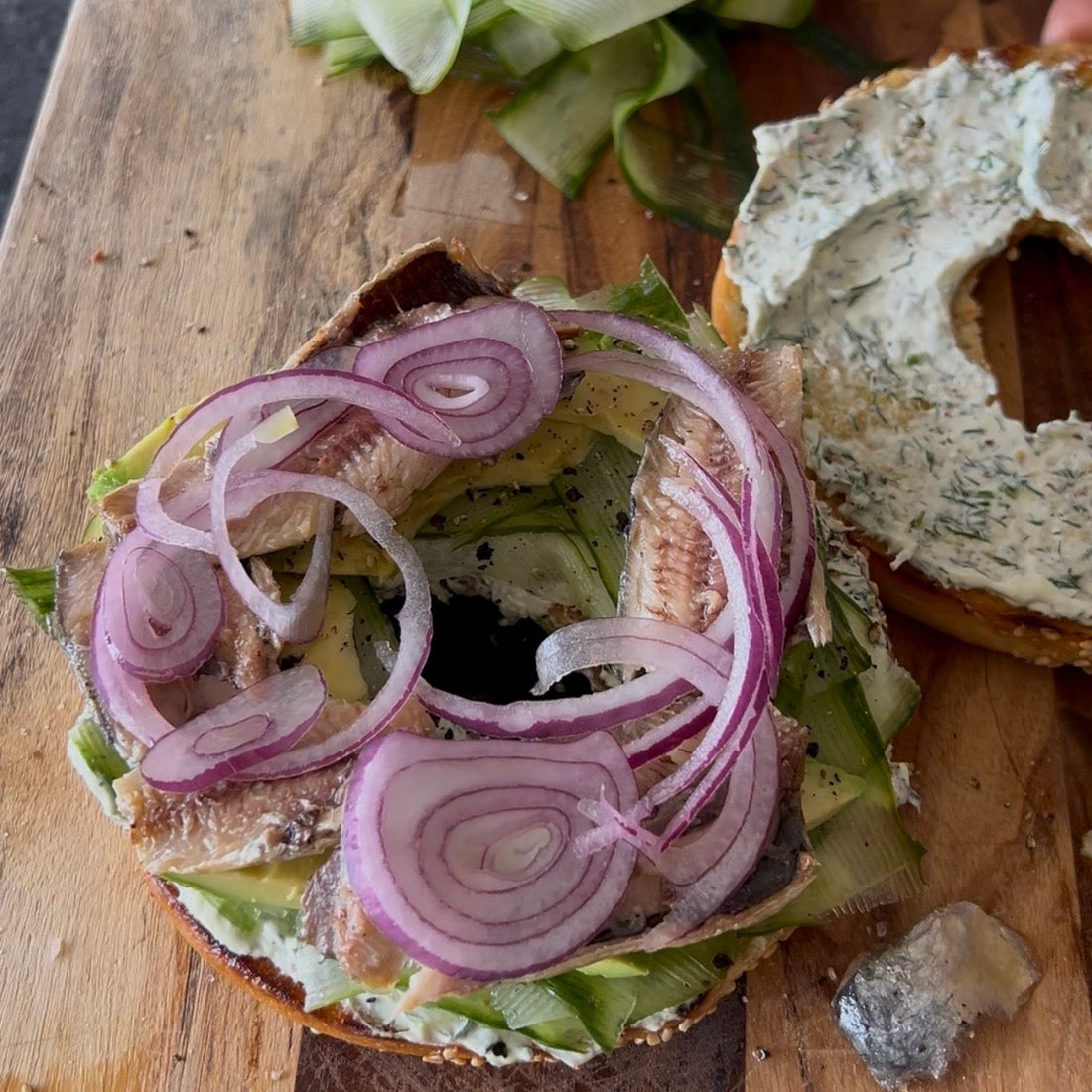 Toasted bagel topped with smoked sardines, avocado, cucumber and lemon cream cheese.