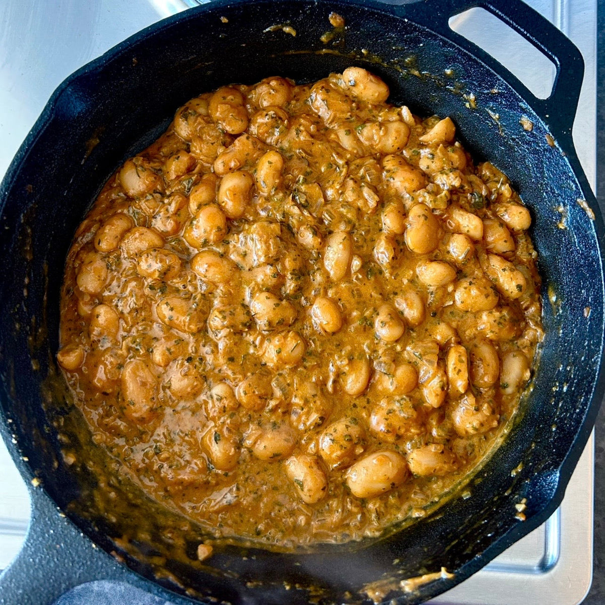 Four comforting butter bean recipes, including curry, creamy garlic beans, pesto stew and tomato ragù